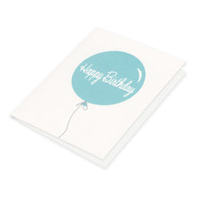 Single elegant large pale blue balloon says Happy Birthday on white background paired with soft gray envelope.